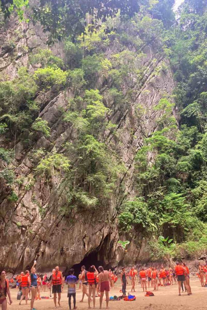 Emerald Cave Koh Mook limestone cliff with tourists in orange life vests